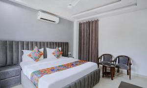 ein Schlafzimmer mit einem großen Bett und einem Stuhl in der Unterkunft FabExpress Dream Living in Neu-Delhi
