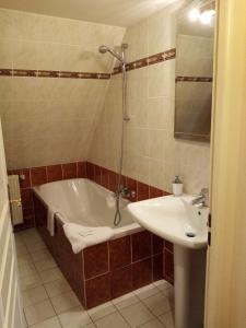 y baño con bañera y lavamanos. en Domaine de launay blot, Proche MT ST MICHEL, en Baguer-Morvan