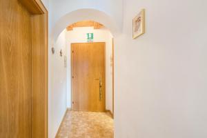 a hallway with a wooden door in a room at Eichernhof Apartment Apfelblüte in Verano