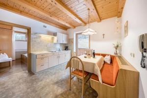 a kitchen with a table and a dining room at Eichernhof Apartment Apfelblüte in Verano