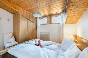 a room with a bed with a red stuffed animal on it at Eichernhof Apartment Apfelblüte in Verano