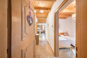 a hallway leading to a bedroom with a bed at Eichernhof Apartment Apfelblüte in Verano