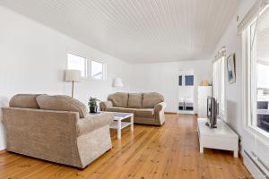 a living room with a couch and a tv at First Camp Solvik-Kungshamn in Väjern