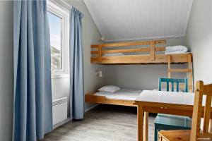 a small room with a bunk bed and a desk at First Camp Solvik-Kungshamn in Väjern