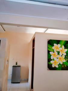 Kaia Lovina Guest House في لوفينا: لوحة من الزهور على جدار في الردهة
