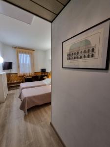 Pokój z dwoma łóżkami i zdjęciem na ścianie w obiekcie CityHotel Cristina Vicenza w mieście Vicenza