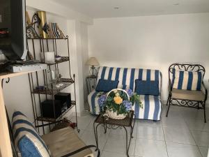 a living room with blue and white striped couches at STUDIO classé 3 étoiles 10 mn Cannes in Le Cannet