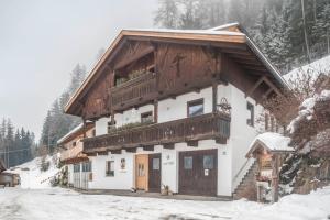 een gebouw met een balkon in de sneeuw bij Mountainfarm Innertrein Wald in Cadipietra