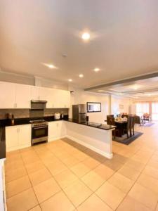a large kitchen with white cabinets and a dining room at Alegria 1E in Kababae