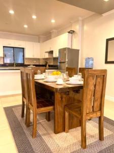 a kitchen with a wooden table with chairs and a counter at Alegria 1E in Kababae