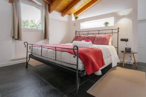 a bedroom with a metal bed with a red blanket at Casa Ananda in Ferno