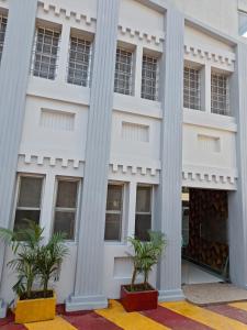 兰奇Hotel Soneva Inn的前面有柱子和棕榈树的建筑