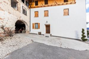 Appartamento Pisani في Brez: اطلالة خارجية على مبنى ابيض مع باب