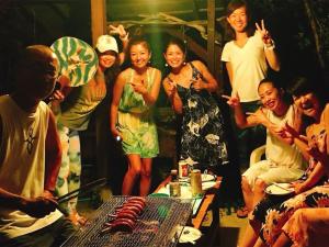 Un groupe de personnes autour d'une table avec de la nourriture dans l'établissement Hide A Way - Vacation STAY 90104v, à Nishinoomote