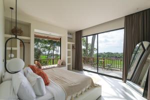 een slaapkamer met een groot bed en een balkon bij Sealuna Villas in Tanah Lot