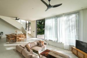 uma sala de estar com um sofá e uma televisão em Sealuna Villas em Tanah Lot