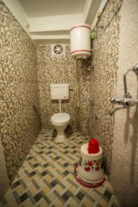 ein Bad mit WC in einem Zimmer mit Tapete in der Unterkunft THE GOLDEN LEAF in Darjeeling