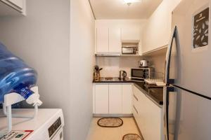 a small kitchen with white cabinets and a refrigerator at QUIET HOME with private beach in Boracay