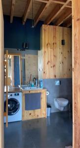 a bathroom with a washing machine and a toilet at Modern Villa & Sauna by the lake, przytulnavilla, Dom nad jeziorem na Mazurach in Ełk