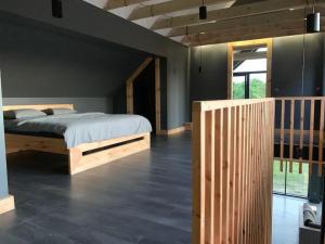 a bedroom with a bed and a wooden wall at Modern Villa & Sauna by the lake, przytulnavilla, Dom nad jeziorem na Mazurach in Ełk