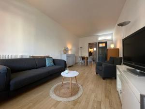 un soggiorno con divano e tavolo di Petite maison de charme a Le Touquet-Paris-Plage