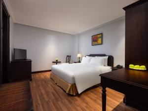 Habitación de hotel con cama, escritorio y cama sidx sidx en Minasi Premium Hotel, en Hanói