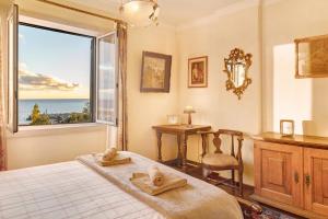 a bedroom with a bed and a window and a desk at Bela Sao Tiago 36 in Funchal
