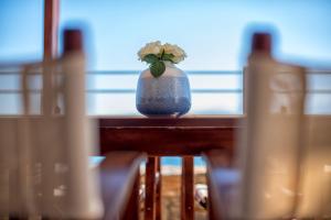 Eine Vase mit einer Blume auf einem Tisch. in der Unterkunft Elounda Maris Villas in Elounda