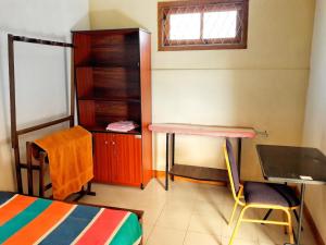a room with a bed and a desk and a table at Galkotuwa Estate in Gelioya