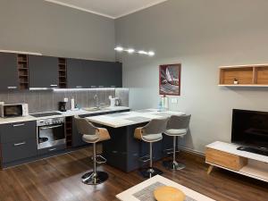una cucina con bancone e sgabelli di Apartament Ratuszowy a Jelenia Góra