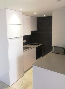 a white kitchen with a stove and a refrigerator at Lykavitos Apartments in Nicosia