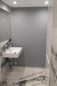 a white bathroom with a sink and a mirror at Lykavitos Apartments in Nicosia