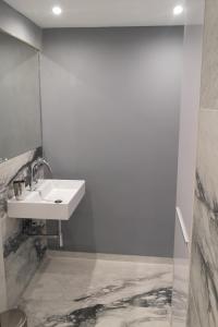 a white bathroom with a sink and a mirror at Lykavitos Apartments in Nicosia +21 photos