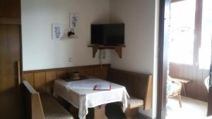 Zimmer mit einem Tisch und einem TV an der Wand in der Unterkunft Krönhof in Bad Kleinkirchheim