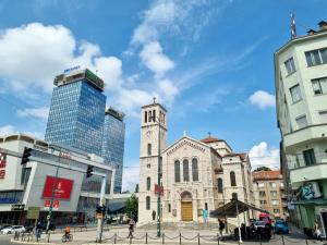 uma velha igreja com uma torre numa cidade em Homy apartment in city center Marijin Dvor em Saraievo