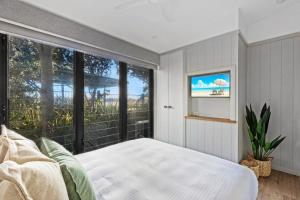 1 dormitorio con cama y ventana grande en Reflections Urunga - Holiday Park, en Urunga