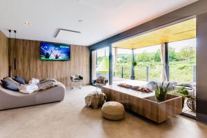 Plitvice Holiday Resort في غرابوفاك: غرفة معيشة مع أريكة وتلفزيون