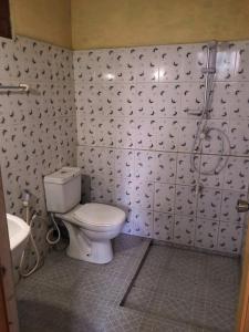 a bathroom with a toilet and a shower at Galkotuwa Estate in Gelioya