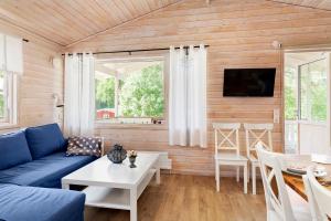 uma sala de estar com um sofá azul e uma mesa em First Camp Torekov-Båstad em Torekov