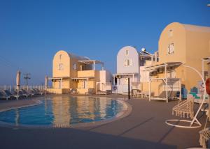 a resort with a swimming pool in front of buildings at Maria's Place - Adults Only in Oia