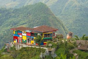 a colorful house on a hill with mountains in the background at Sapa Fantasea Homestay in Sapa