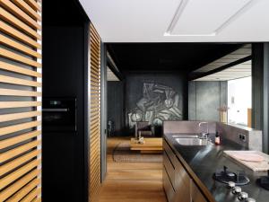 una cocina con armarios negros y fregadero en CE RESIDENCE, en Gante