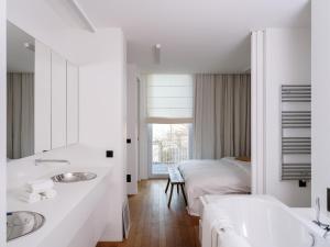 a white bathroom with two sinks and a bed at CE RESIDENCE in Ghent