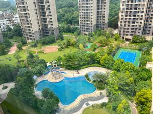 広州市にあるGuangzhou Nanhong Ausotel Hotelの高層ビルが立ち並ぶ公園内のプールの空中ビュー