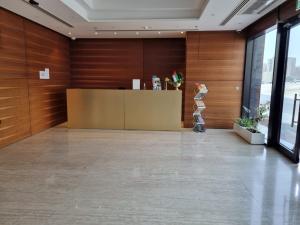 a lobby with a reception desk and a statue in the middle at Grand Stay Holiday Homes Al Jaddaf in Dubai