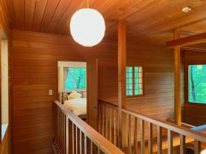 a bedroom with wooden walls and a staircase in a house at 星の街S115# Nature Escape BBQ in Azumaiokozan