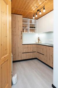 a kitchen with wooden cabinets and white appliances at Hiša Rodica in Bohinj