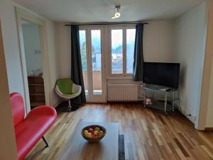 a living room with a television and a bowl of fruit at Uptown Apartments Interlaken free Parking in Interlaken