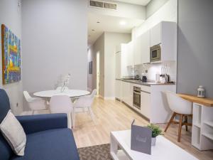 a living room and kitchen with a table and chairs at Arenal Suites Gran Vía in Madrid