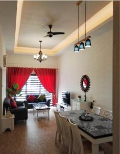 a living room with a dining room table and a couch at Cameron Lovely Home 3 Rooms in Tanah Rata